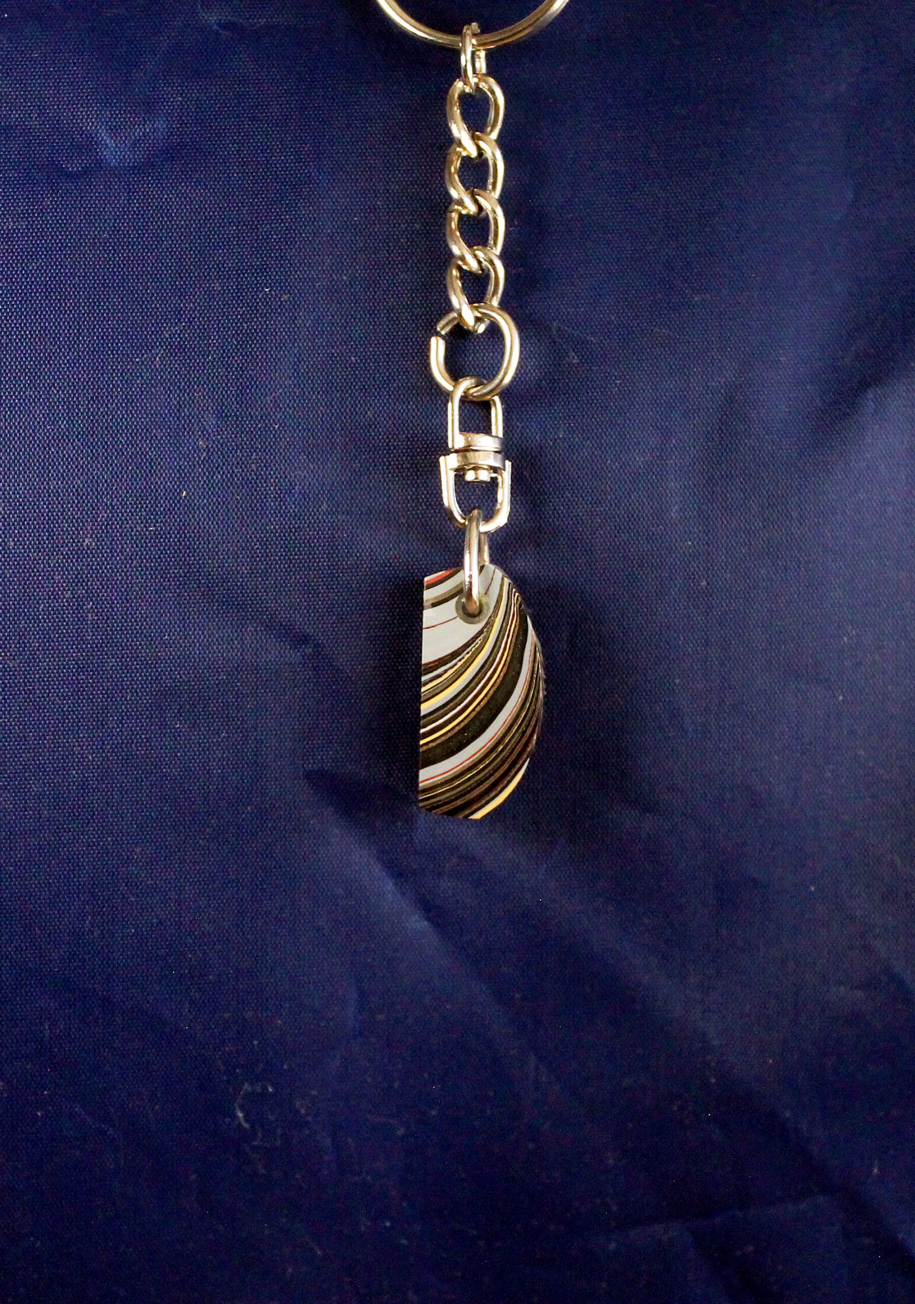 Keychain with a decorative striped pendant.