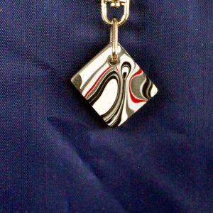 Abstract patterned pendant on blue background.