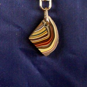 Colorful layered pendant on blue background.