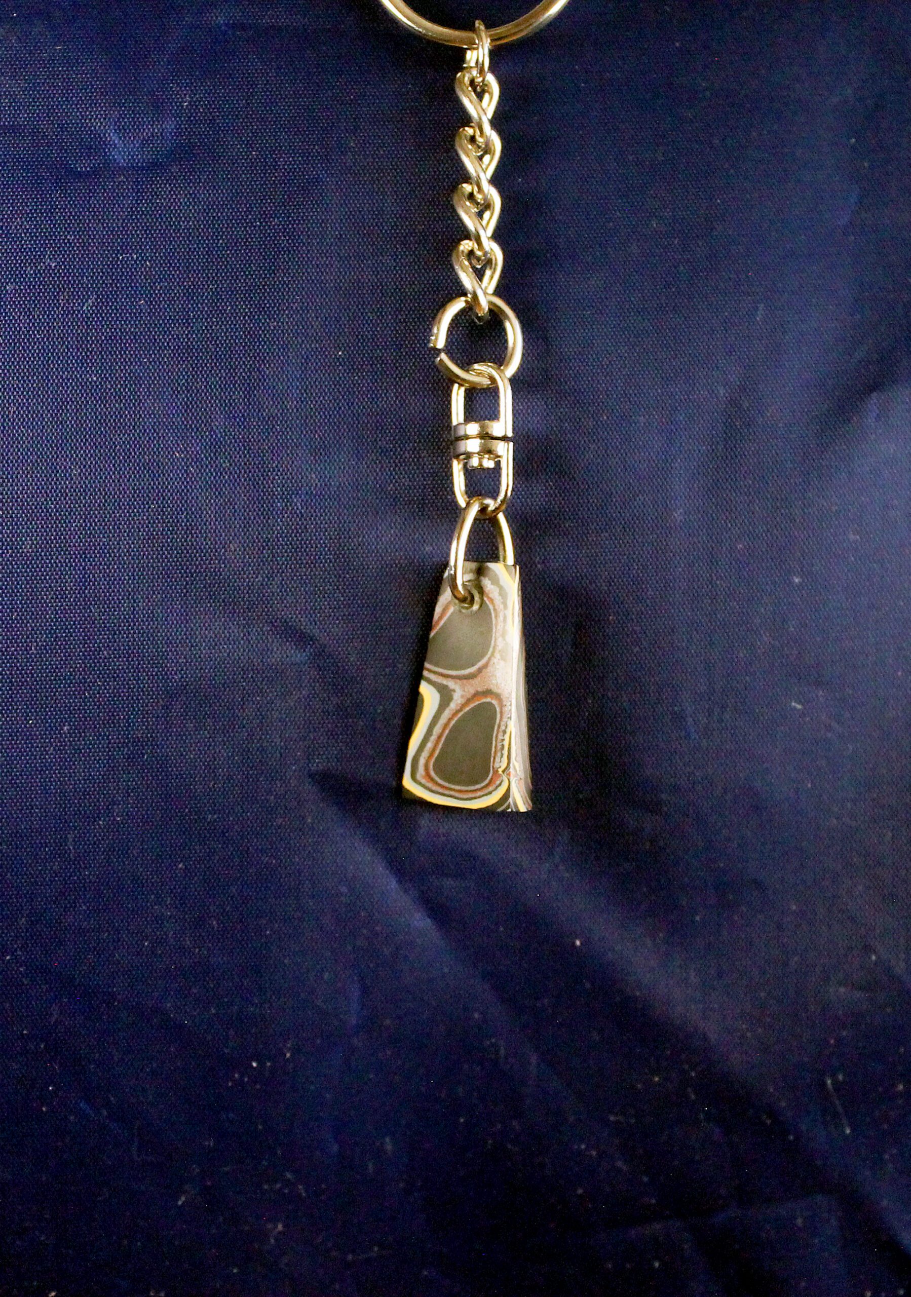 Keychain with abalone shell pendant on blue.