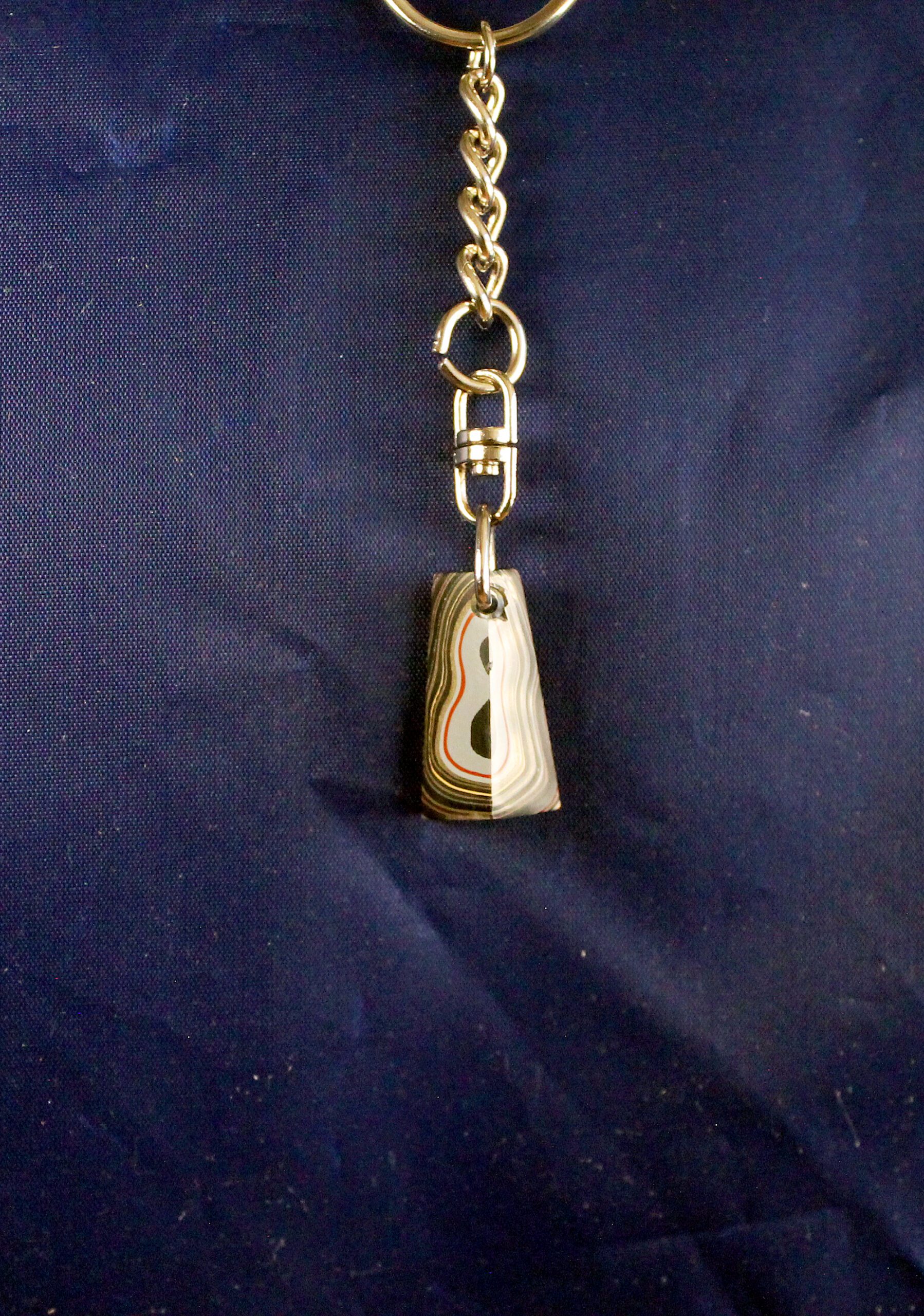 Keychain with a small striped pendant.