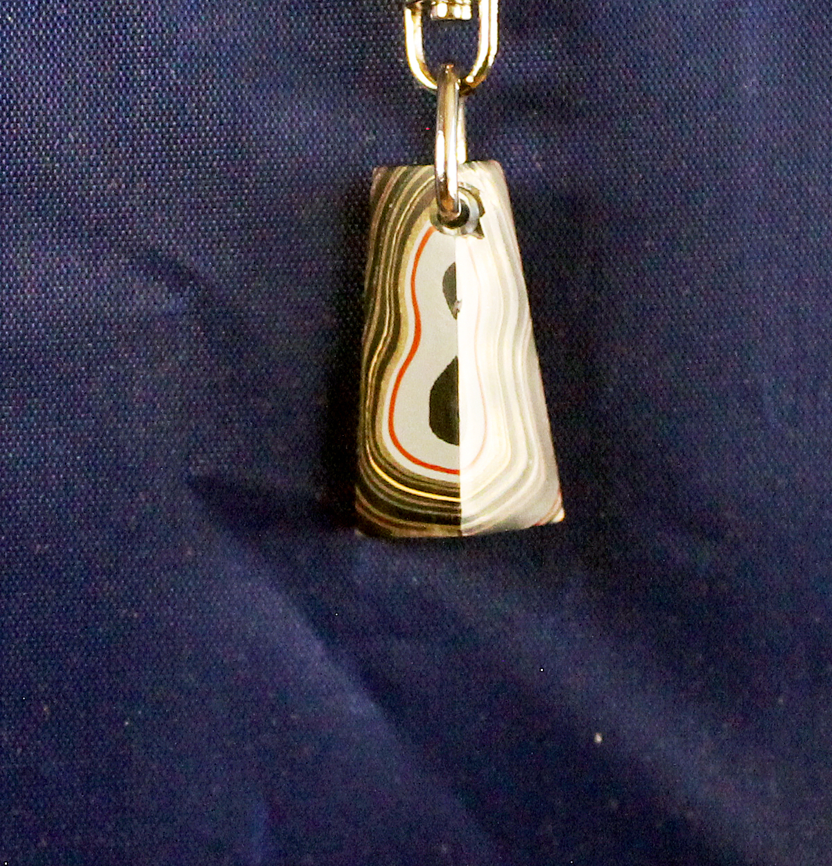 Keychain with layered design on blue background.