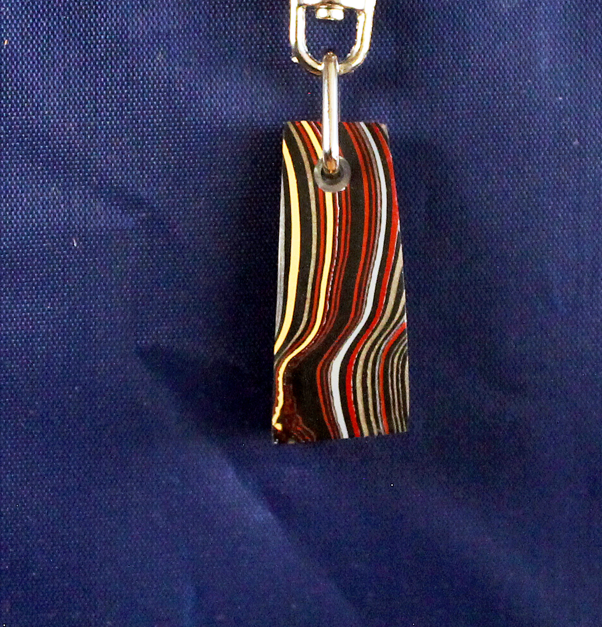 Striped keychain on blue fabric background.