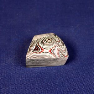 Layered patterned object on blue background.