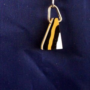 Gold and black pendant on blue background.