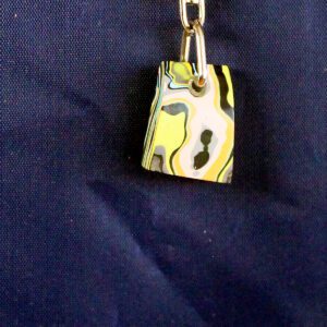 Colorful pendant on a blue fabric background.