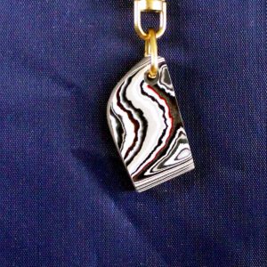 Striped pendant on blue fabric background.