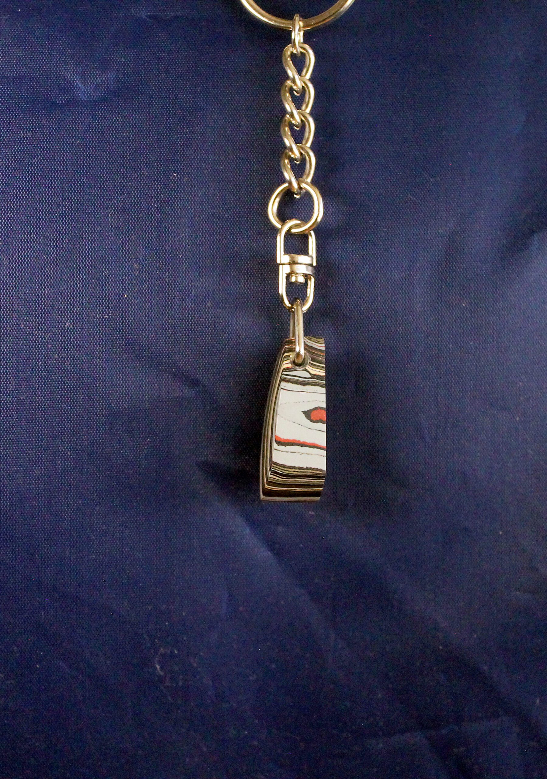 Keychain with abstract pattern on dark background.