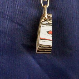 Keychain with layered pendant on navy background.