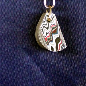 Colorful layered keychain on blue fabric.
