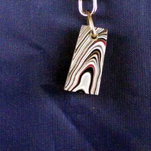 Striped pendant on blue fabric background.
