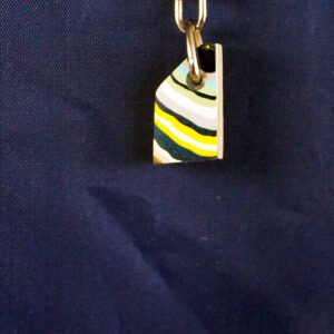 Colorful striped keychain on dark fabric background.