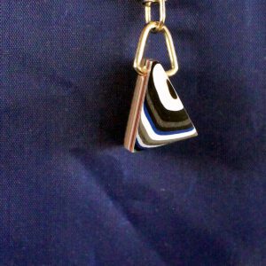 Triangular keychain on a blue background.