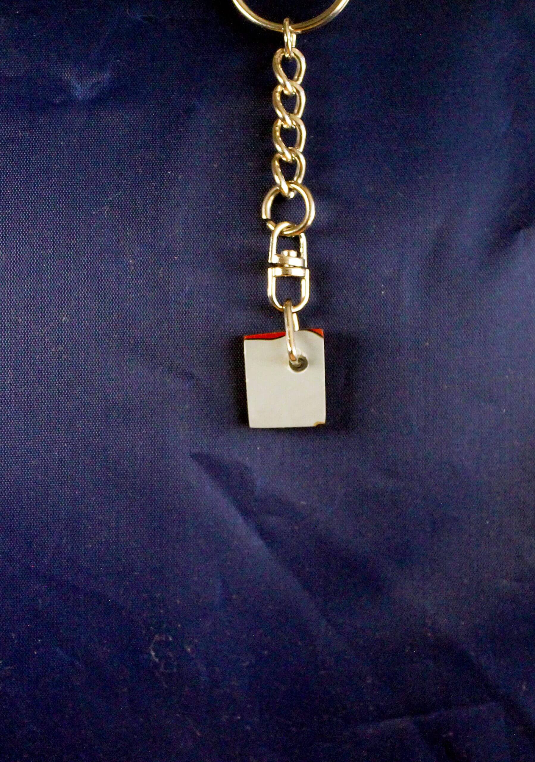 Keychain with small notepad on blue background.