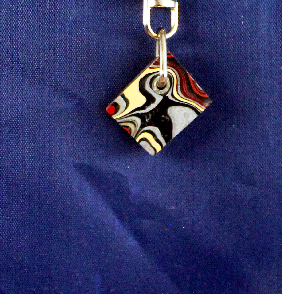 Colorful abstract pendant on blue background.