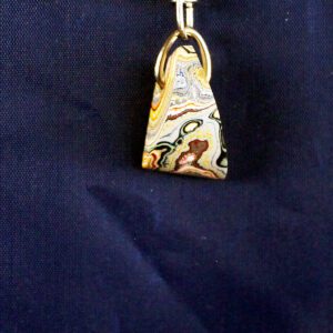 Colorful keychain pendant on dark fabric background.