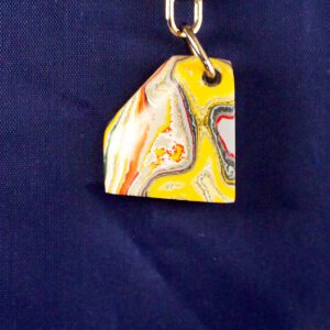Colorful marbled keychain on blue background.