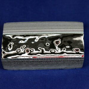 Metal block with intricate layered patterns.