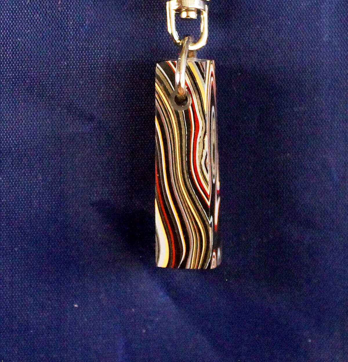 Colorful striped keychain against blue background.