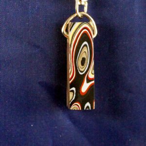 Colorful patterned keychain against blue background.