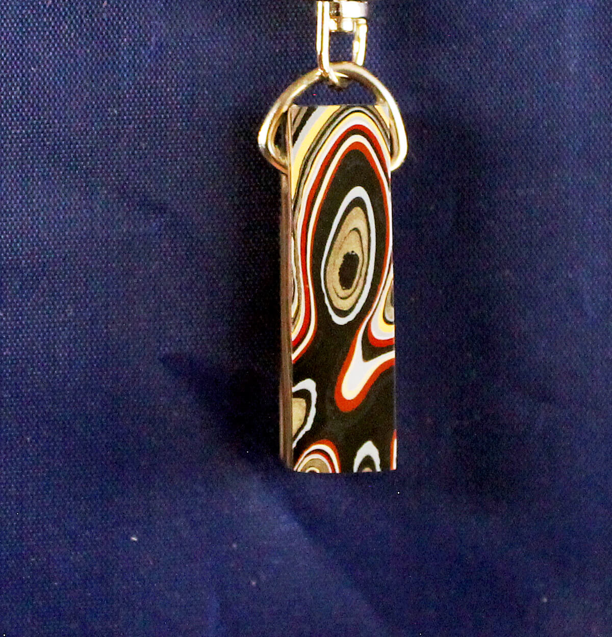 Colorful patterned keychain against blue background.