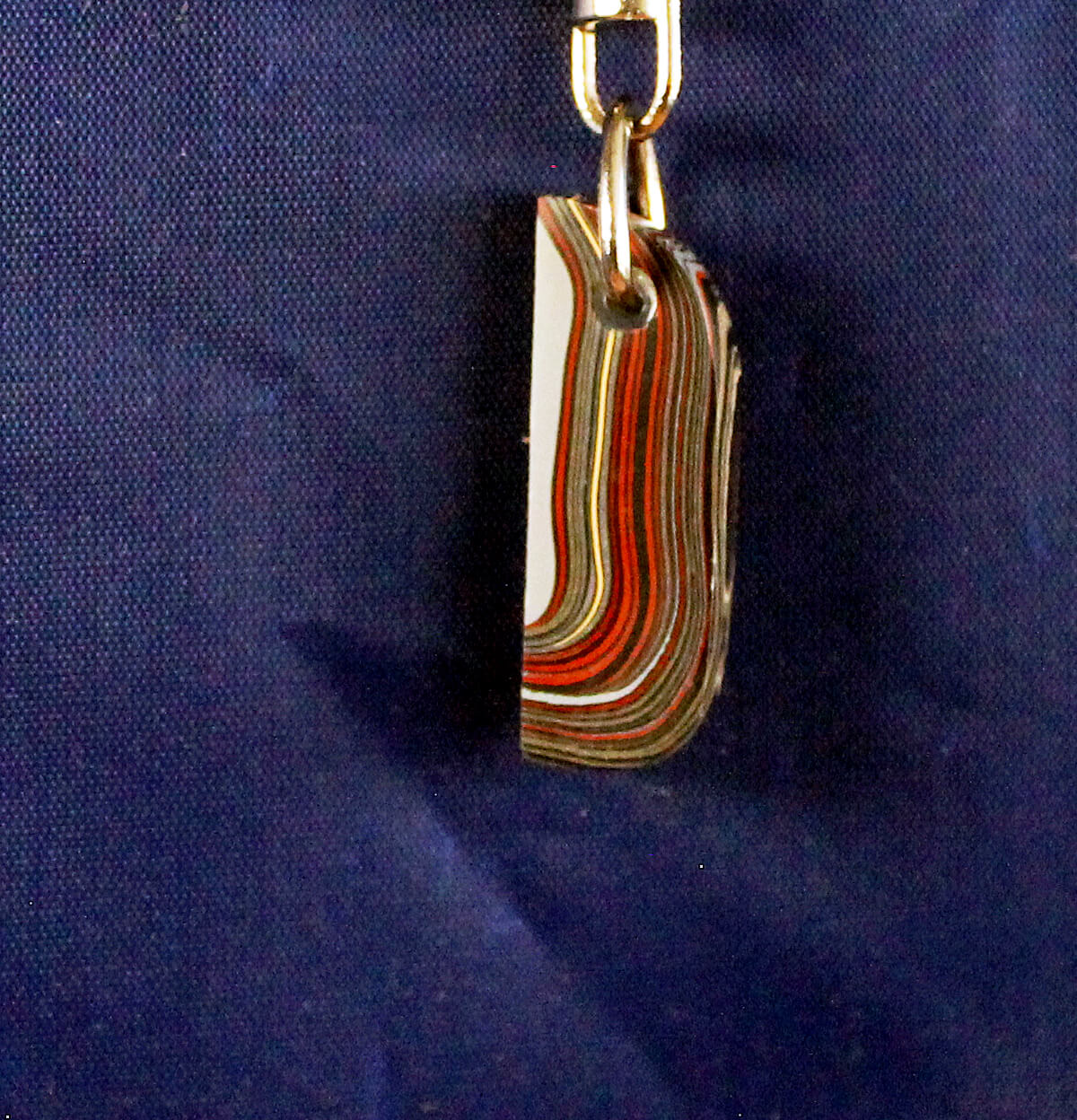 Layered paint chip keychain on blue background.