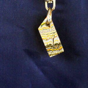 Colorful abstract keychain against dark background.