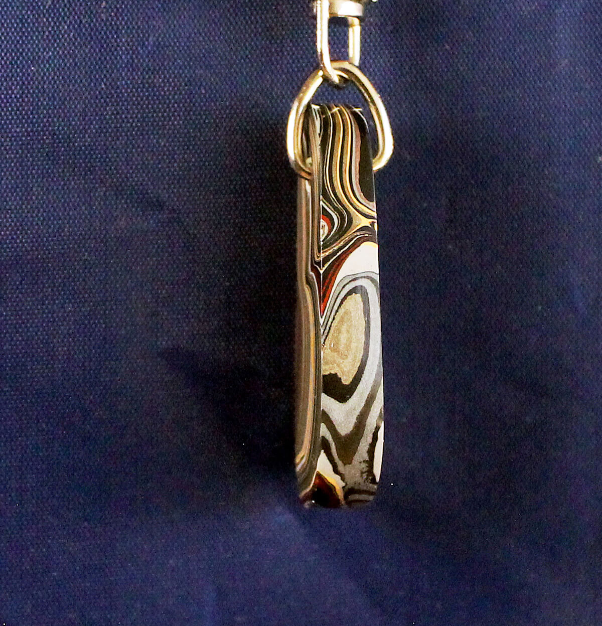 Marbled keychain against dark blue background.