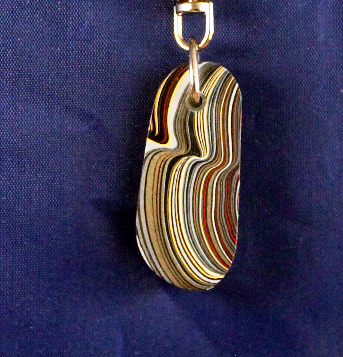 Colorful layered pendant against a blue background.