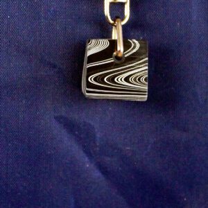 Keychain with black and white striped cube.