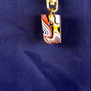 Colorful patterned pendant on blue background.