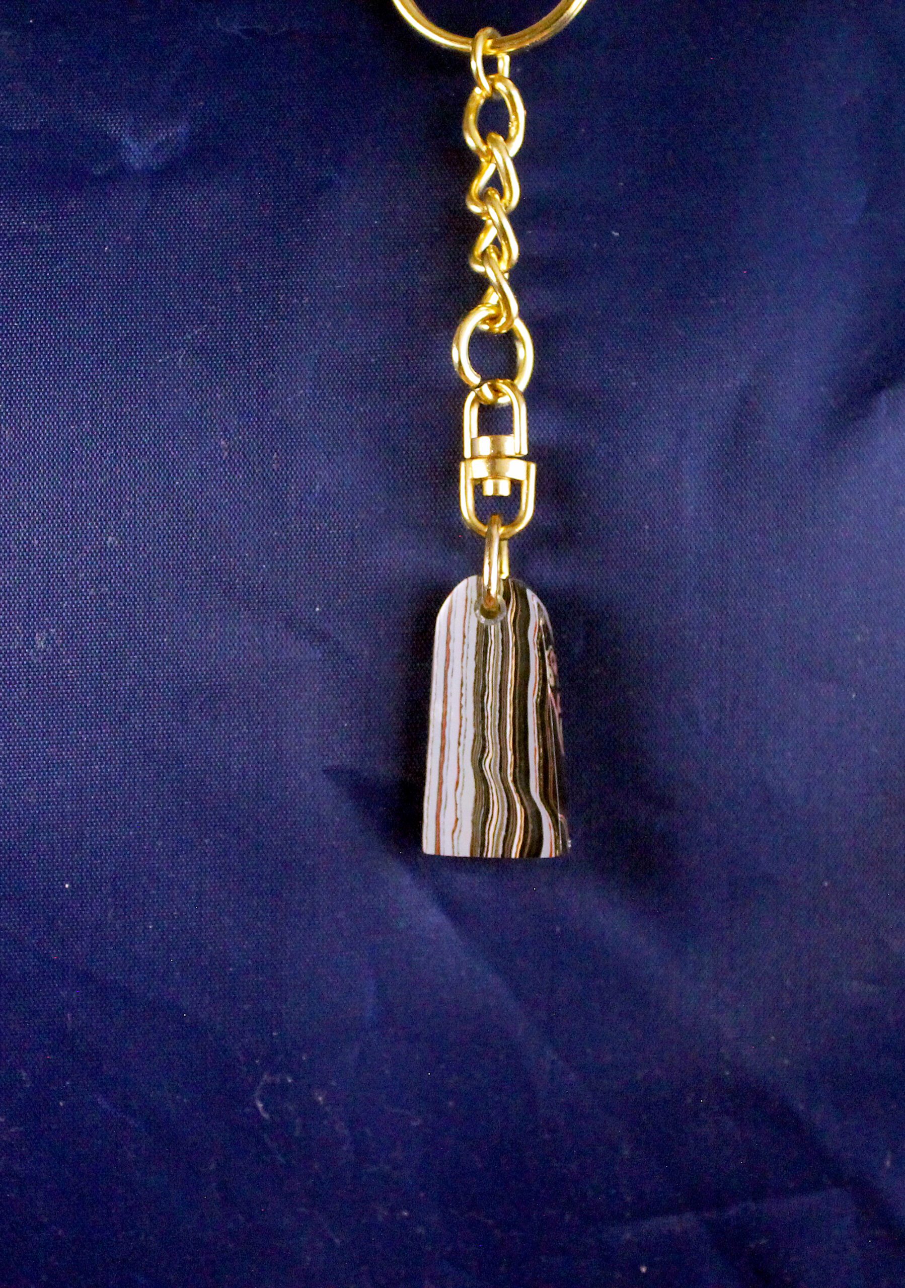 Gold chain with striped stone pendant.