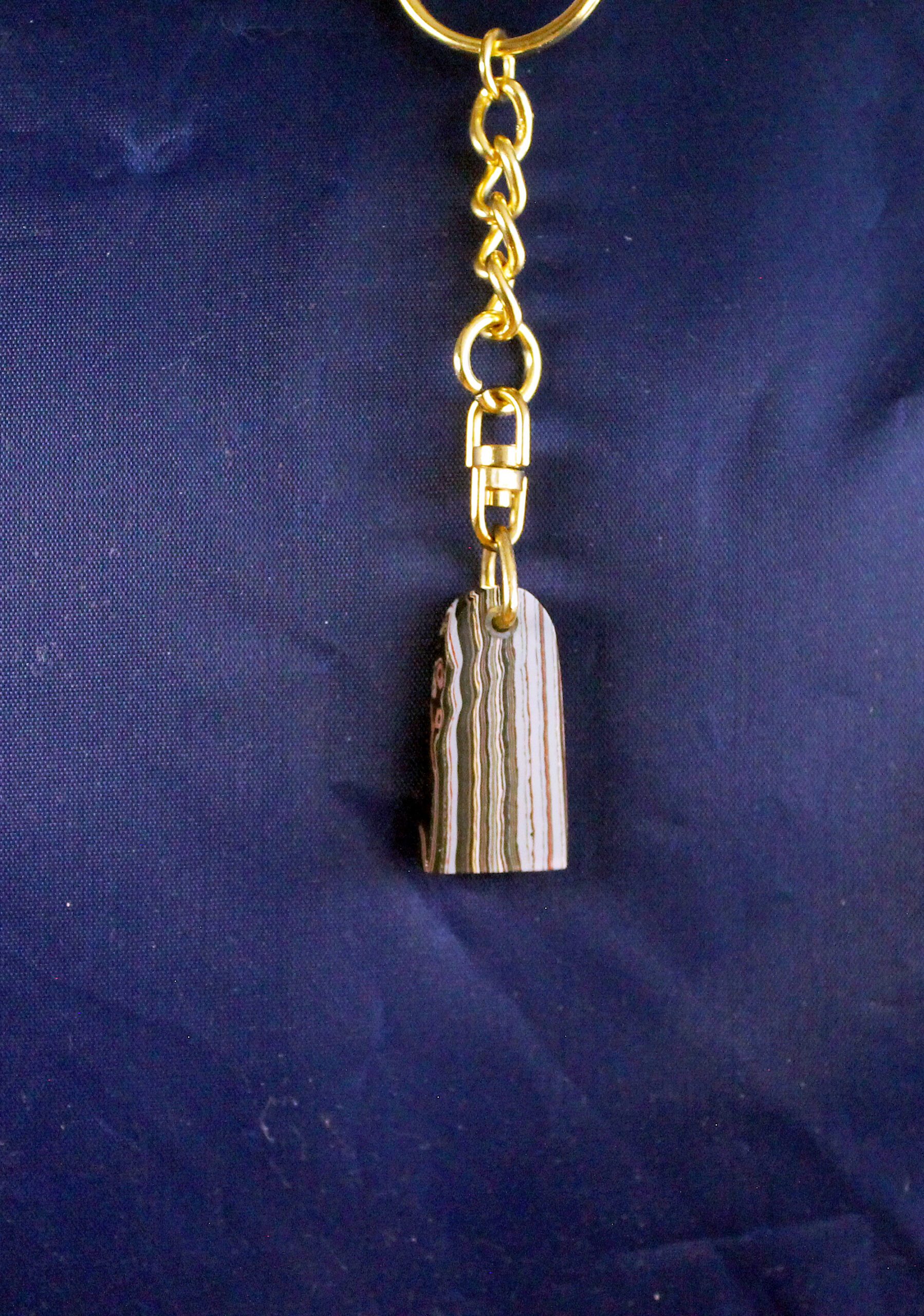 Gold keychain with striped stone pendant.