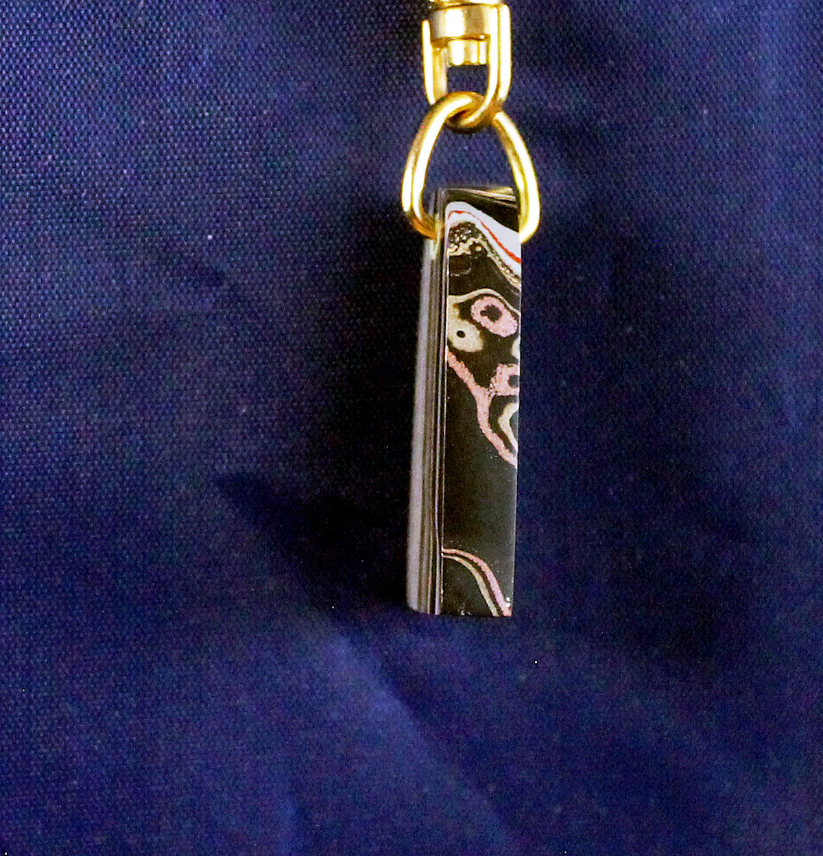 Black and gold keychain on blue background.