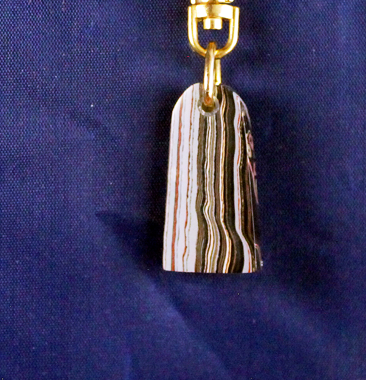 Striped stone pendant on gold keychain.