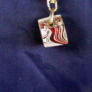 Keychain with red and black swirl design.