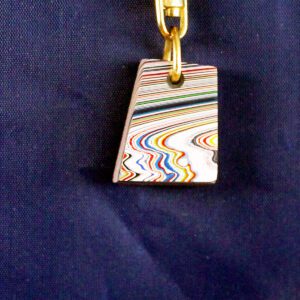 Colorful pendant with swirling patterns on fabric.