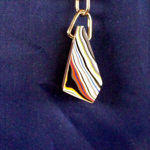 Colorful layered keychain against dark background.