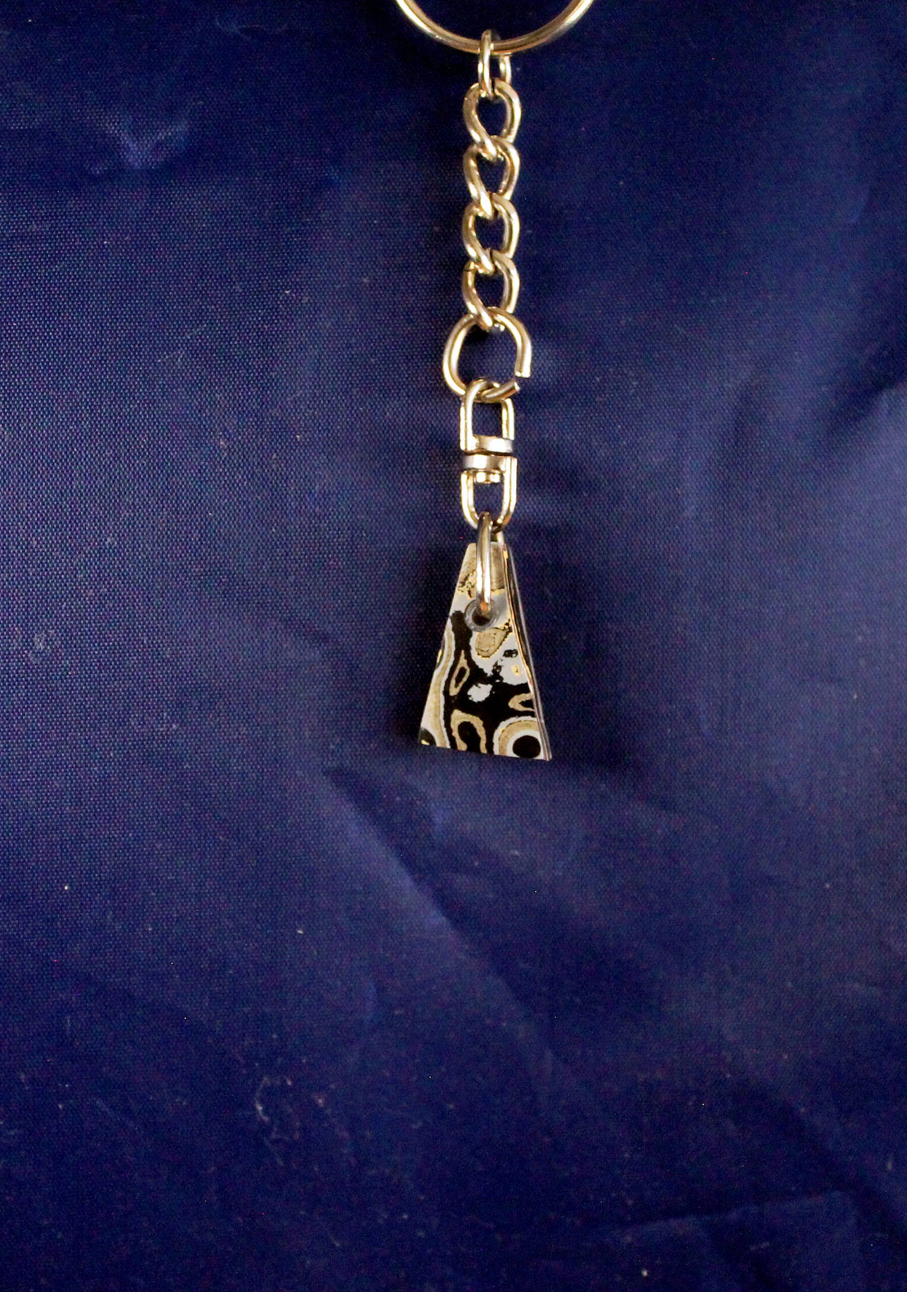 Keychain with patterned triangular pendant.