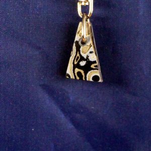 Triangular patterned pendant on blue fabric.