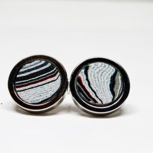 Striped round cufflinks on white background.