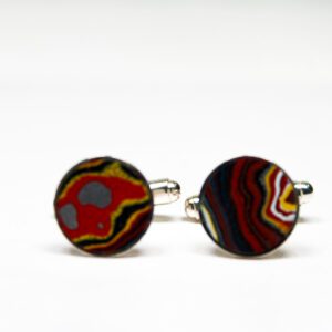 Colorful round cufflinks on white background.
