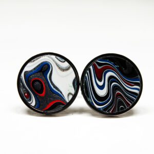 Abstract patterned round earrings on white background.