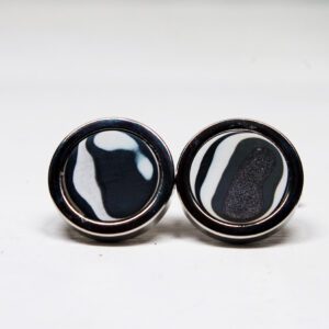 Black and white round cufflinks on display.