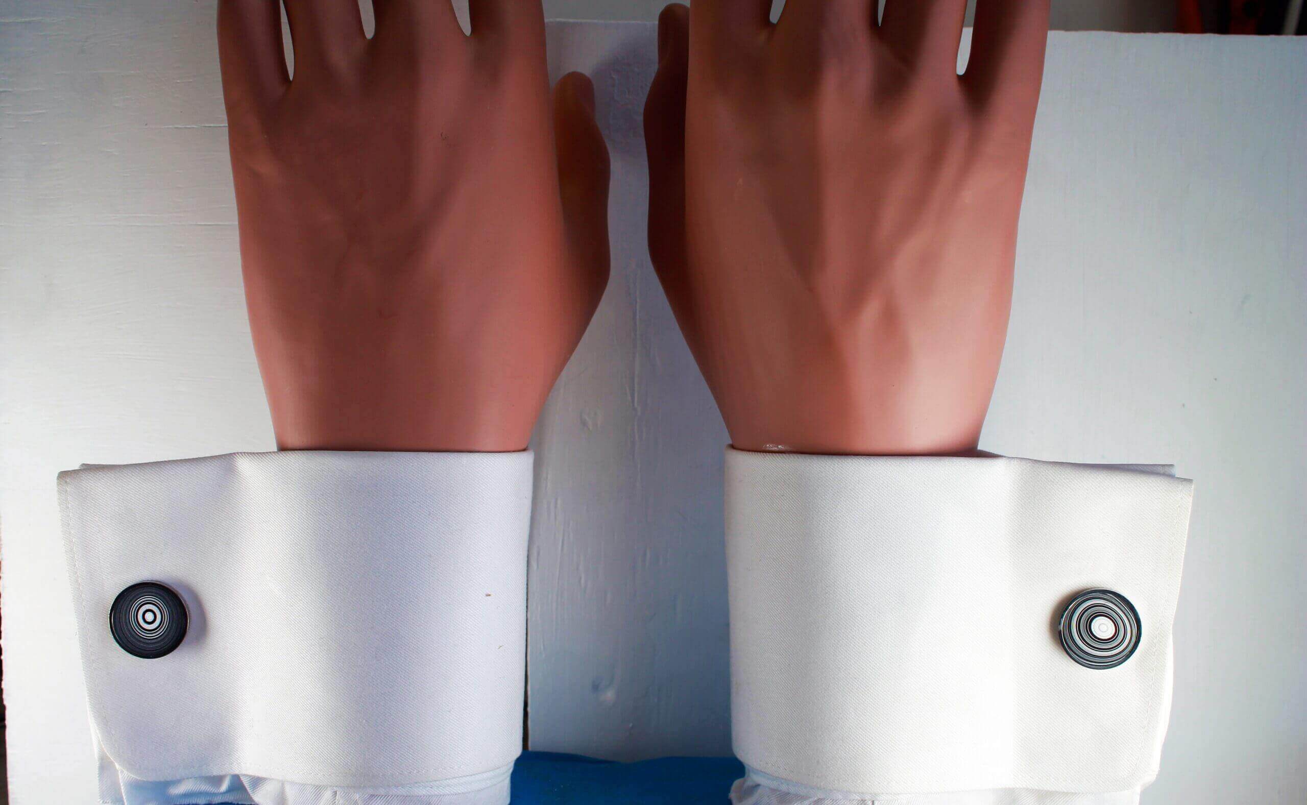 Hands with white shirt cuffs and buttons.