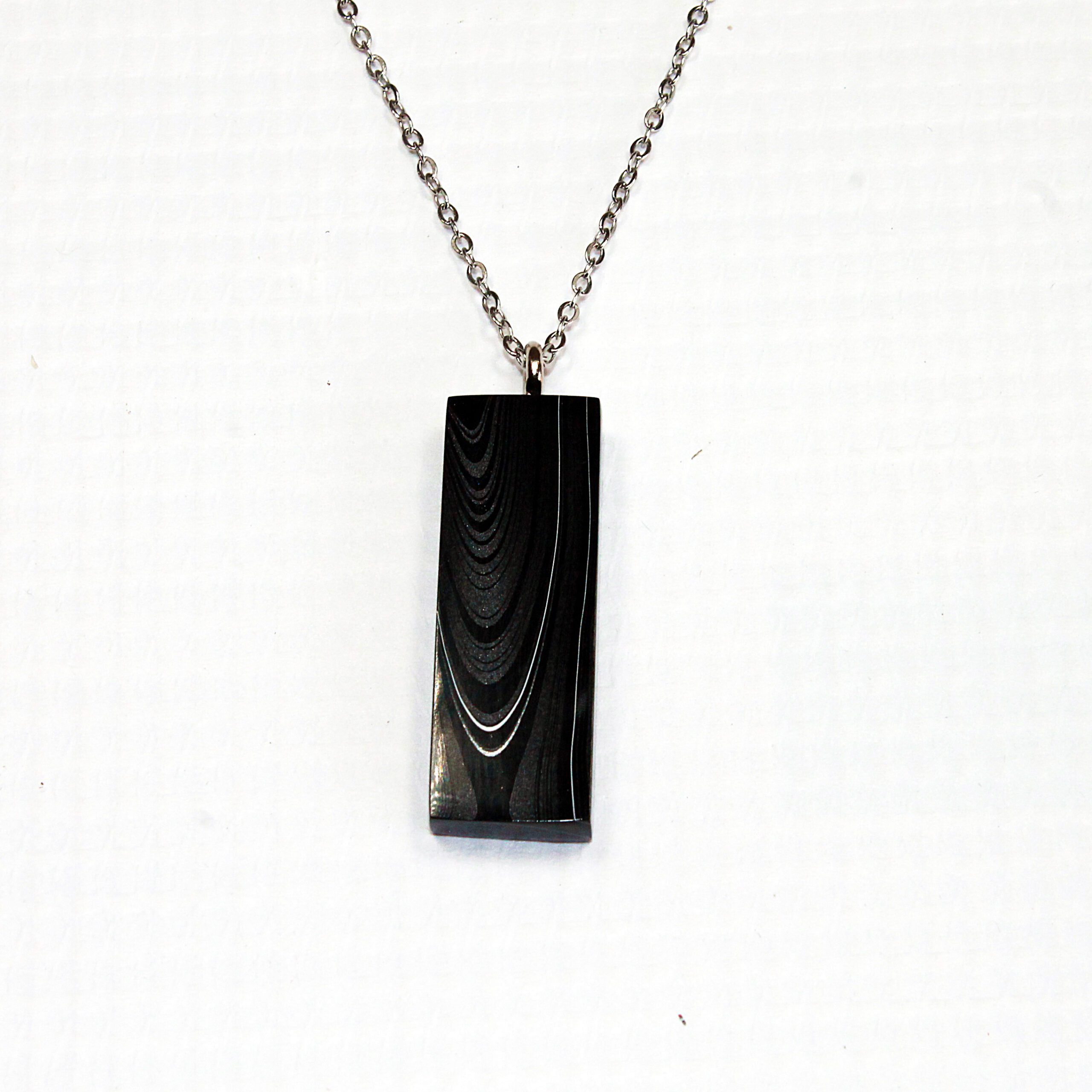 Black pendant necklace on a chain.
