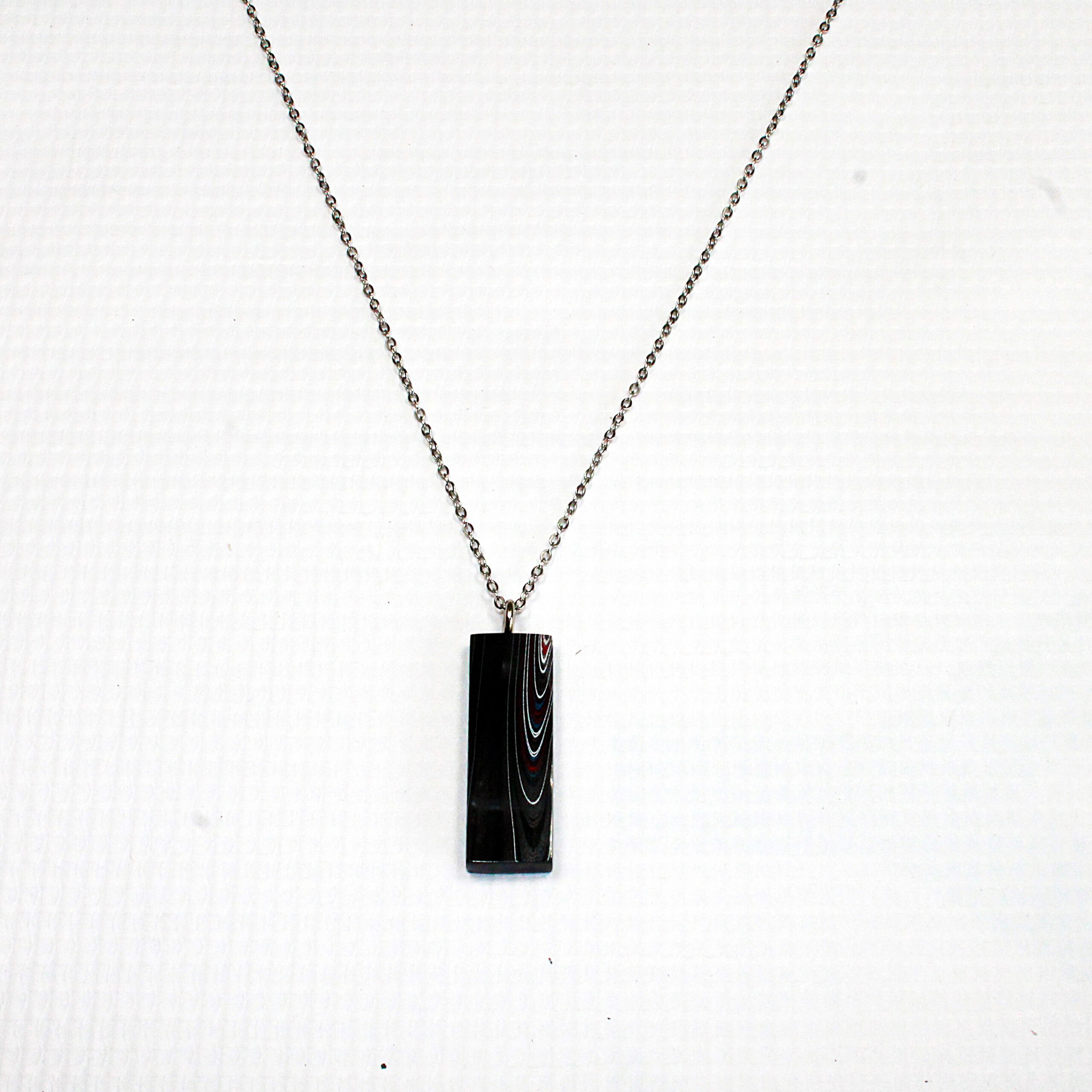 Pendant necklace with rectangular black stone.