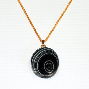 Gold chain with round black pendant.