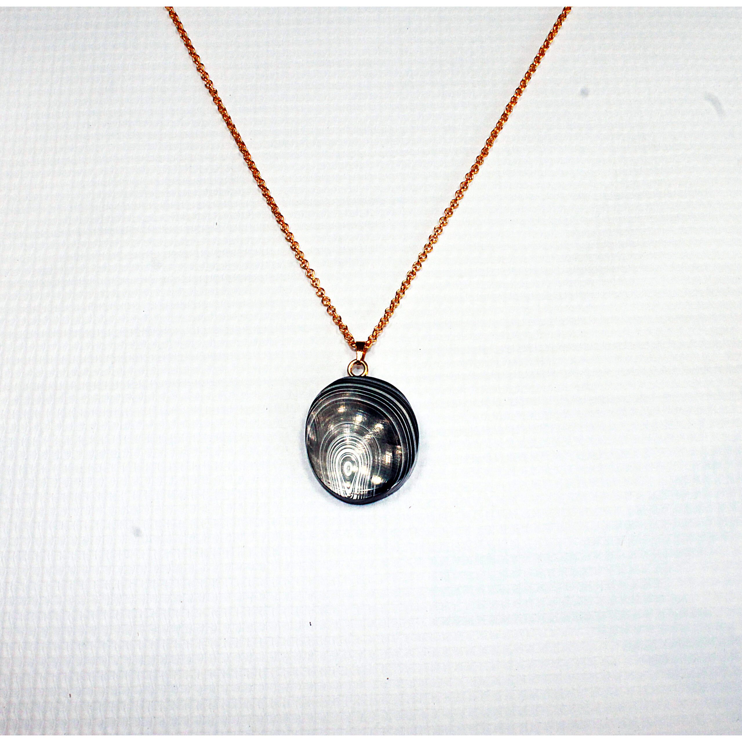 Gold chain with round silver pendant.