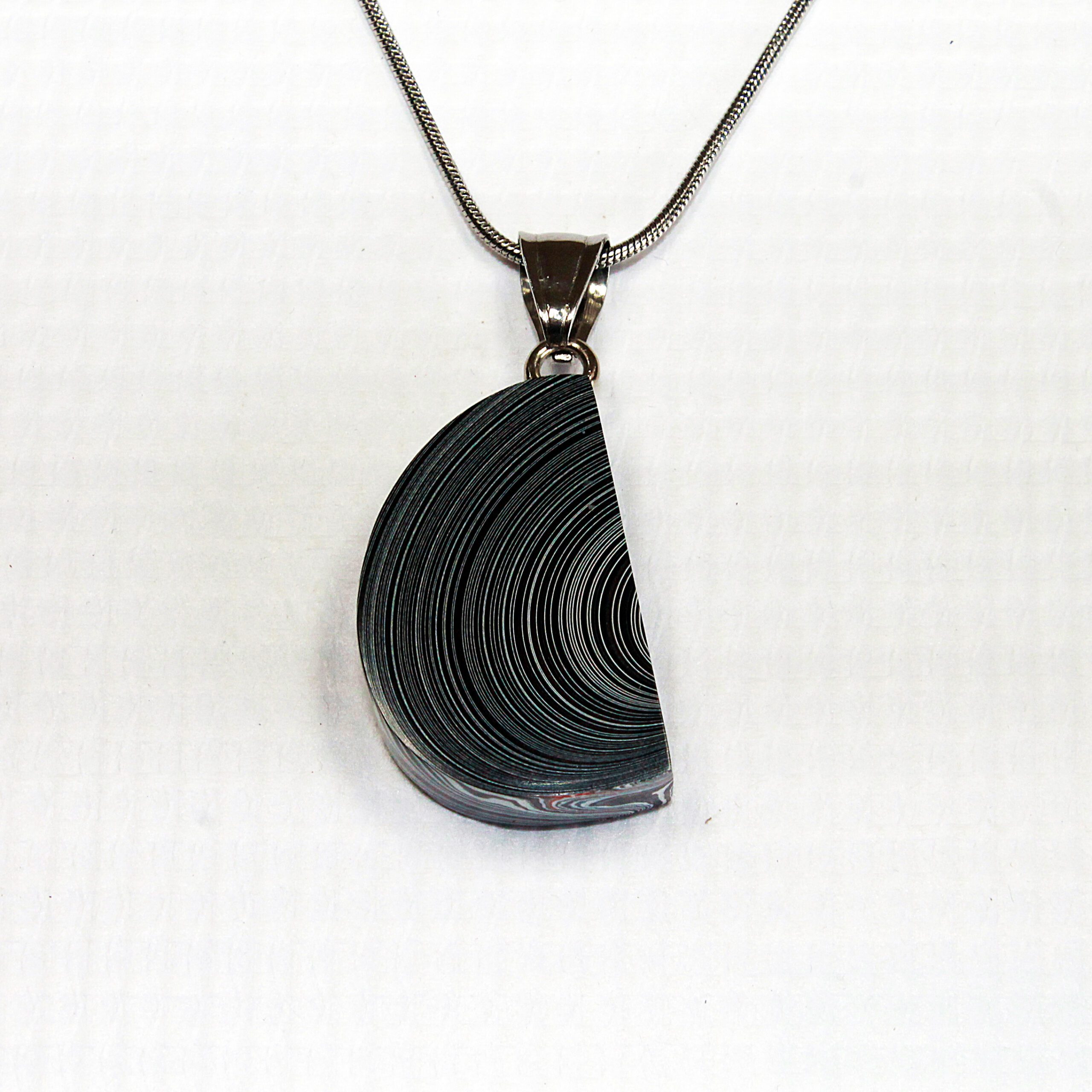 Half-circle pendant with spiral design necklace.